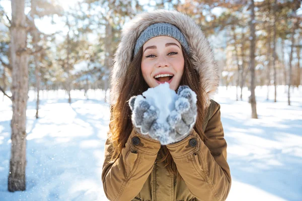 Mujer sosteniendo nieve en parque de invierno —  Fotos de Stock