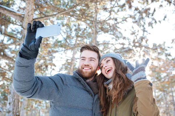 Paar foto maken op smartphone in winter park — Stockfoto