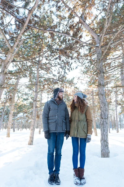 Счастливая молодая пара стоит в зимнем парке — стоковое фото