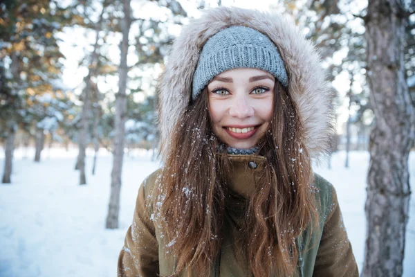 Lächelnde Frau mit warmem Hut und Jacke mit Kapuze — Stockfoto