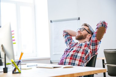 Eller başının arkasında oturan ve rahatlatıcı neşeli adam