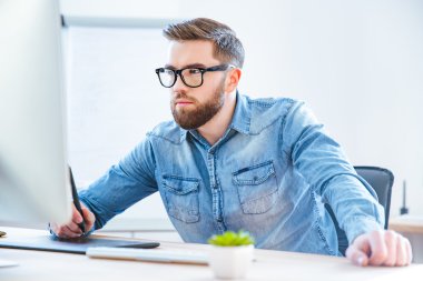 Ciddi konsantre adam Tasarımcısı grafik kalem tablet ile çizim 