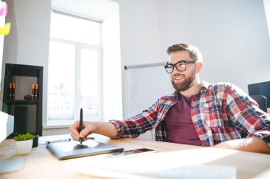 Gülümseyen sakallı tasarımcı çizim ve grafik kalem tablet kullanma 