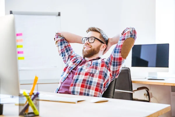 Lycklig man sitter med händerna bakom huvudet och avkopplande — Stockfoto