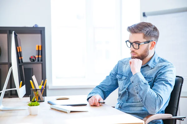 Diseñador reflexivo utilizando la tableta gráfica y el ordenador — Foto de Stock