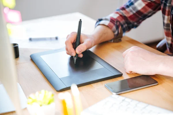 Tablet pena hitam dengan stylus yang digunakan oleh tangan desainer laki-laki — Stok Foto