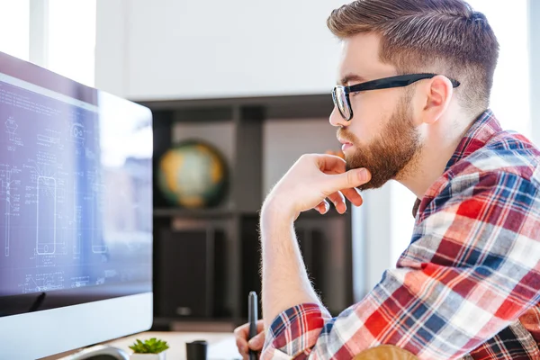 Concentré homme dans les lunettes dessin des plans sur ordinateur — Photo