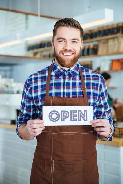 Χαρούμενα όμορφος καφετέρια εργαζόμενο κρατώντας πινακίδα ανοιχτό καφέ — Φωτογραφία Αρχείου