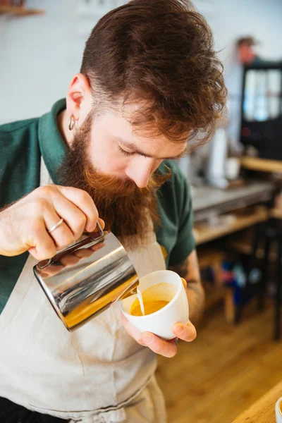 Barista pouring milk into cup of coffee — Stock Photo, Image