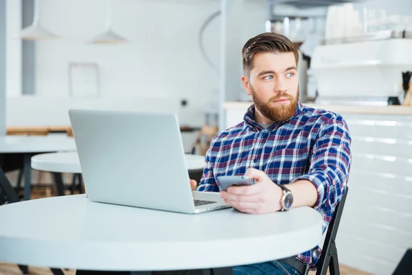 Hombre pensativo con ordenador portátil en la cafetería — Foto de Stock