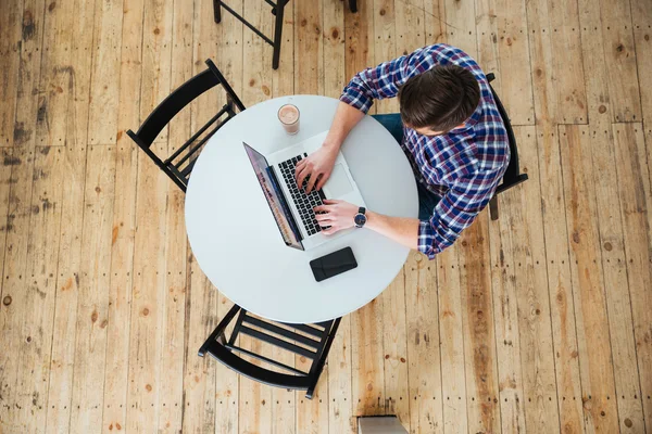 Mann benutzt Laptop in Café — Stockfoto