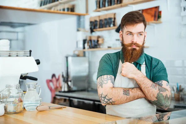 Bonito barista homem pensativo tocando sua barba e pensando — Fotografia de Stock