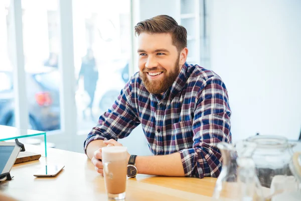 Man zit aan de tafel met cappuccino — Stockfoto