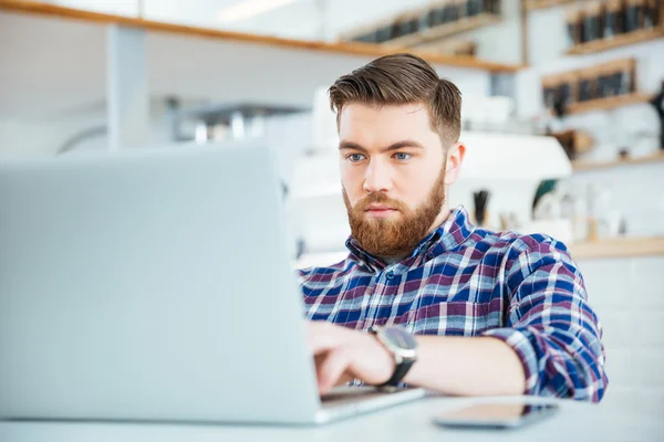 Mann benutzt Laptop in Café — Stockfoto