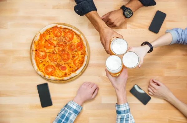 Мультиэтническая группа молодых людей, которые пьют пиво и едят пиццу — стоковое фото