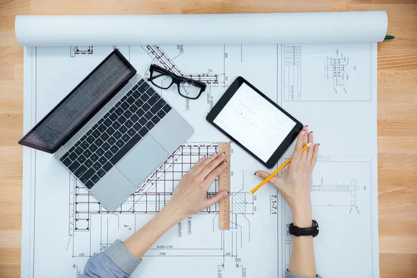 Joven arquitecta trabajando y haciendo planos — Foto de Stock