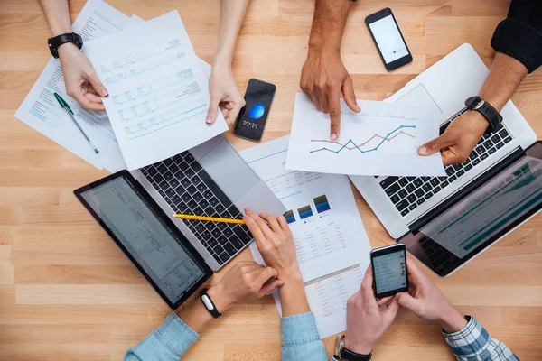 Equipo que trabaja para el informe financiero utilizando computadoras portátiles y teléfonos inteligentes — Foto de Stock