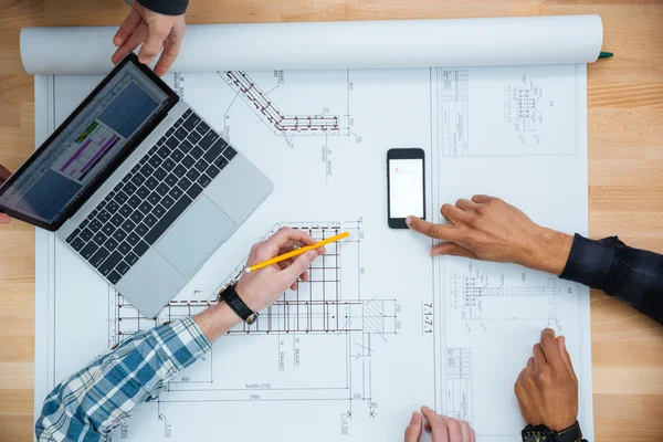 Groep mensen werken met laptop, smartphone en blauwdruk — Stockfoto