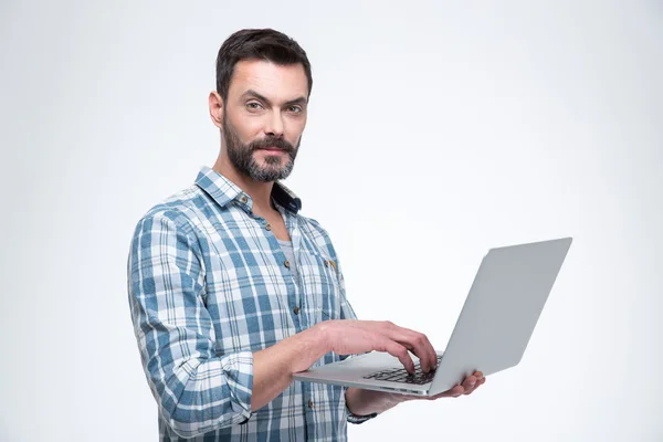 Mann benutzt Laptop und schaut in Kamera — Stockfoto