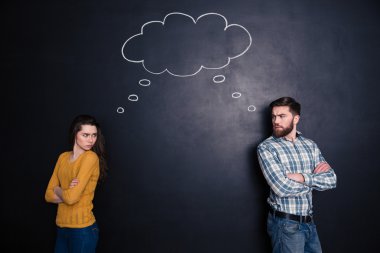 Kızgın çift düşünme aynı şekilde kara tahta arka plan üzerinde çatık