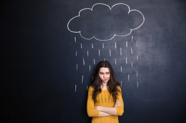Unpleased woman with raincloud drawn over her on blackboard background  clipart