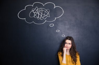Thougthful woman thinking about problems over blackboard background