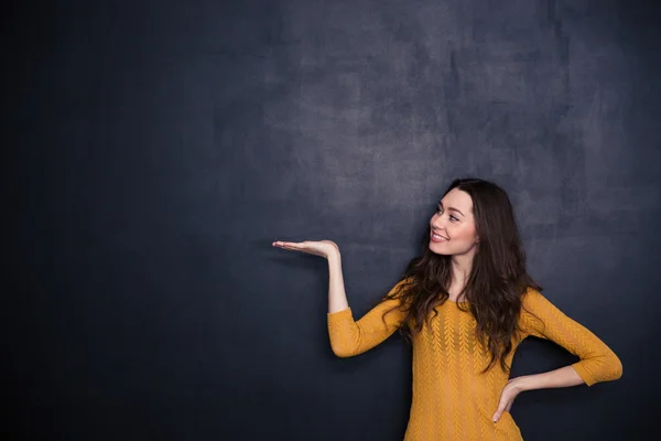 Donna felice che tiene il copyspace sul palmo della mano — Foto Stock