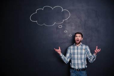 Bağırarak ve tahta arka plan üzerinde duran kızgın adam