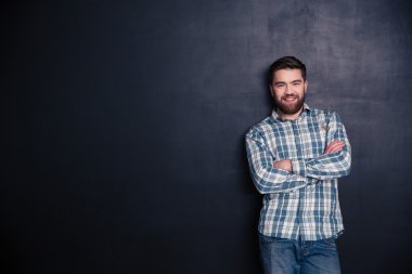 Mutlu genç adam katlanmış silah ile ayakta