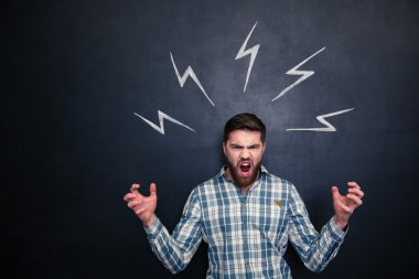 Bağırarak ve yazı tahtası üzerinde çizilmiş Lightning'ler altında duran çılgın adam 