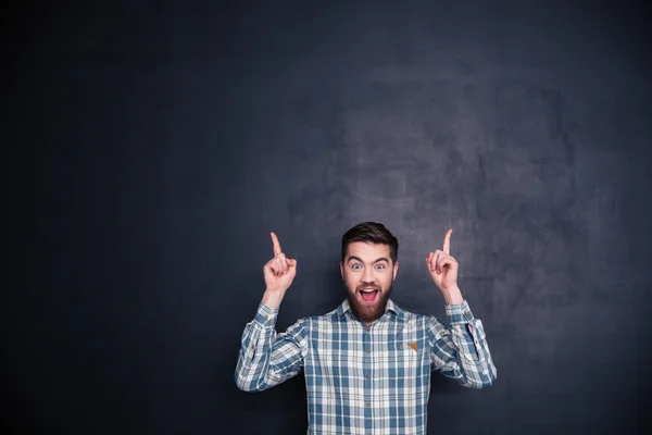 Hombre alegre señalando con los dedos hacia arriba en el copyspace — Foto de Stock