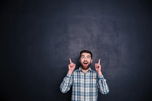 Hombre alegre señalando con los dedos hacia arriba en el copyspace — Foto de Stock