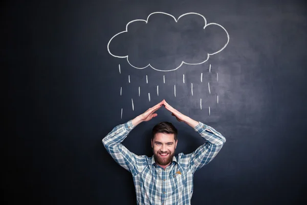 Hombre imitando techo con las manos y cubriendo de lluvia dibujada — Foto de Stock