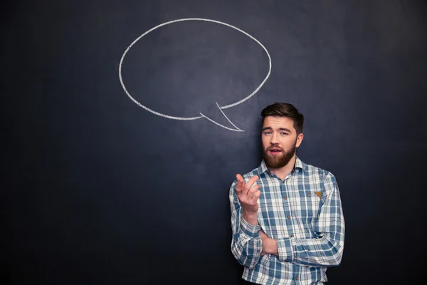 Homme barbu parlant sur fond de tableau noir avec bulle de discours dessinée — Photo