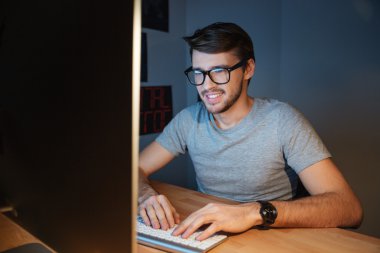 Mutlu adam evde bilgisayarda yazarak gözlük