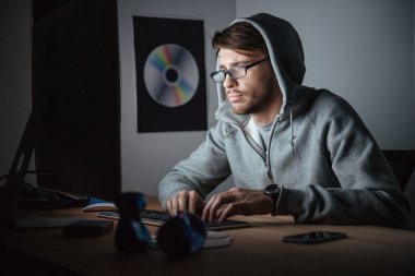 Düşünceli adam gözlük ve bilgisayarda çalışarak hoodie 