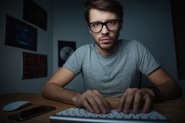 Надійний чоловік сидить удома і друкує на клавіатурі — стокове фото