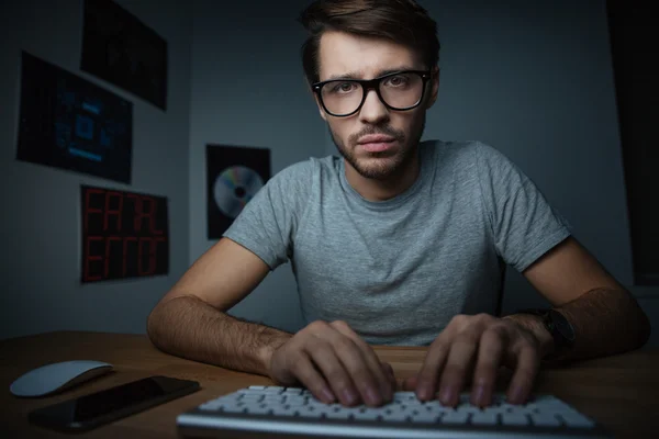 Fundersam man sitta hemma och skriva på tangentbord — Stockfoto