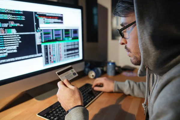 Concentrated hacker in glasses stealing money from diferent credit cards — Stock Photo, Image