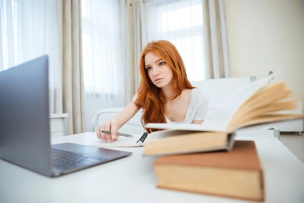 Жінка сидить за столом з домашнім завданням — стокове фото