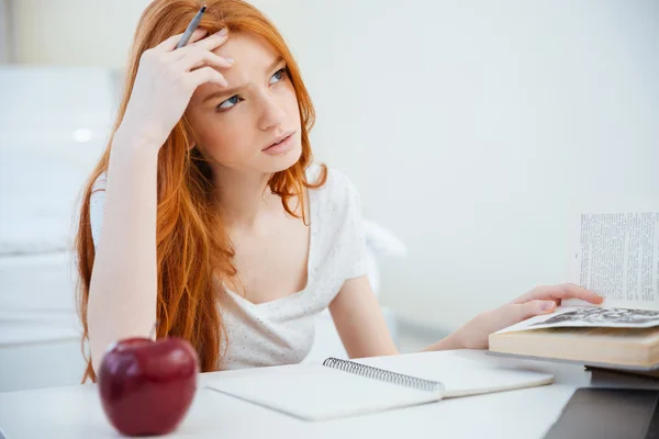 Vrouw haar huiswerk na te denken — Stockfoto