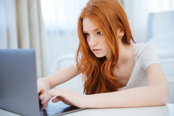 Mulher usando computador portátil em casa — Fotografia de Stock