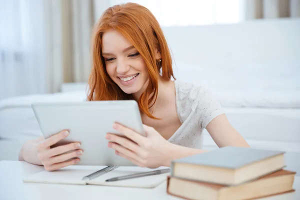 Femme rousse assise à la table avec ses devoirs — Photo