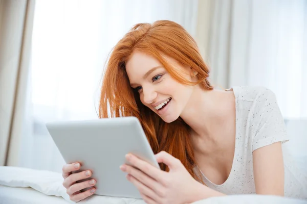 Vrouw liggend op het bed met tablet computer — Stockfoto