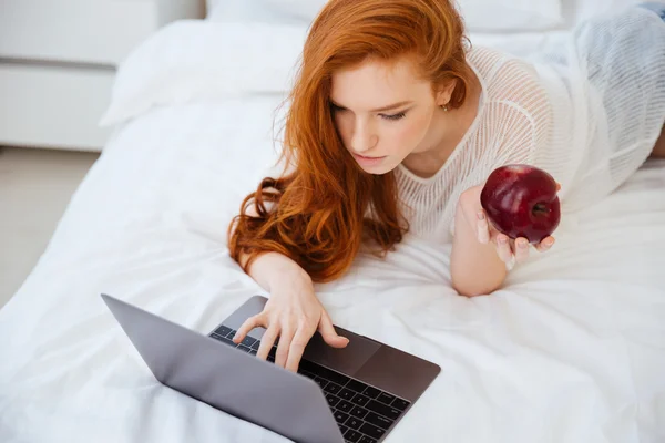 Woman using laptop computer on the bed — Stock Photo, Image