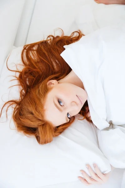 Jolie rousse aux cheveux longs couchée au lit — Photo