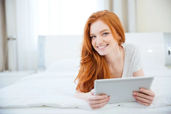 Woman lying on the bed with tablet computer Royalty Free Stock Images