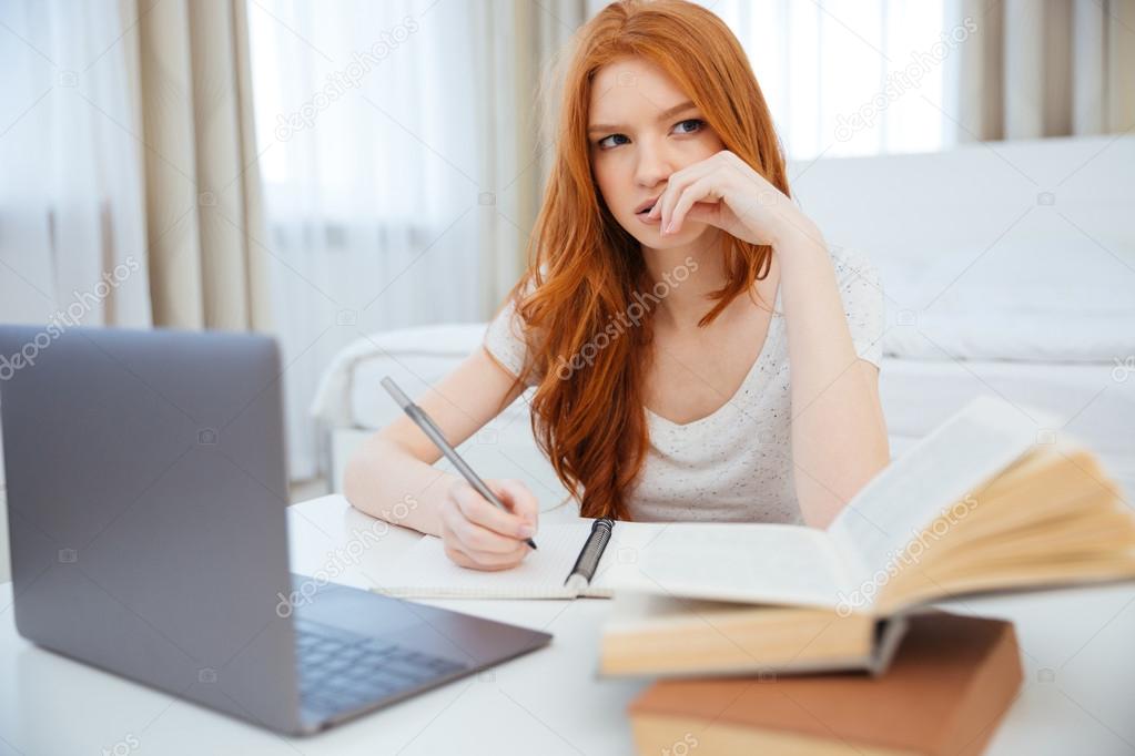 Redhead woman doing homework at home