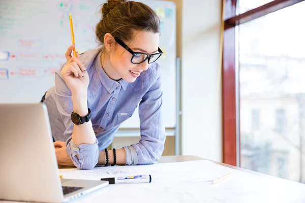 Happy woman working with blueprint near the window in office — Stock Photo, Image