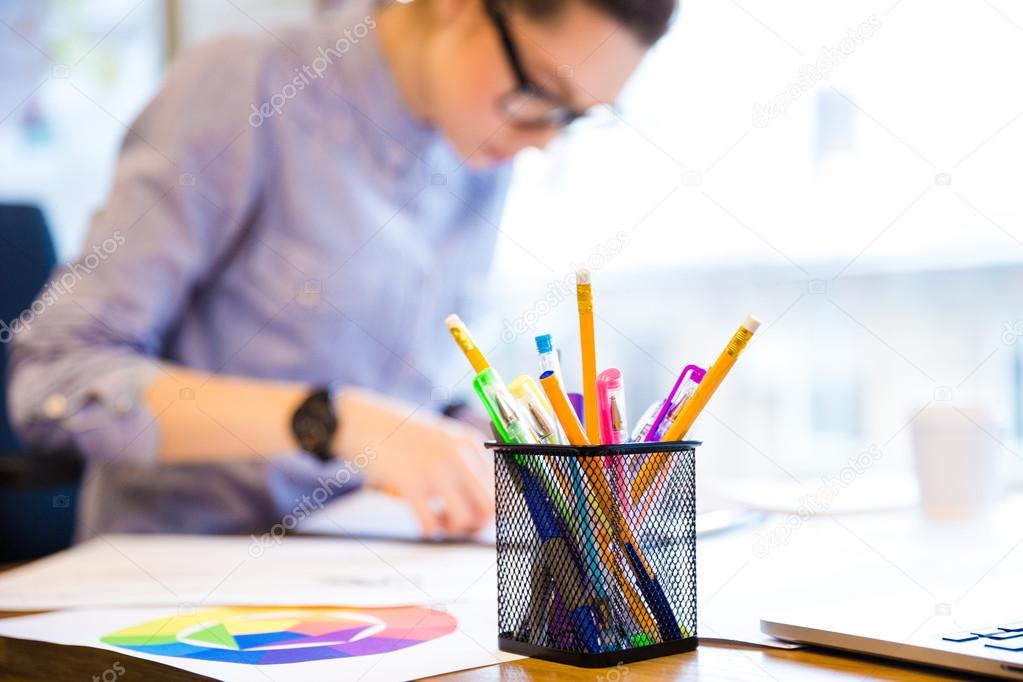 Serious female fashion designer making sketches in office